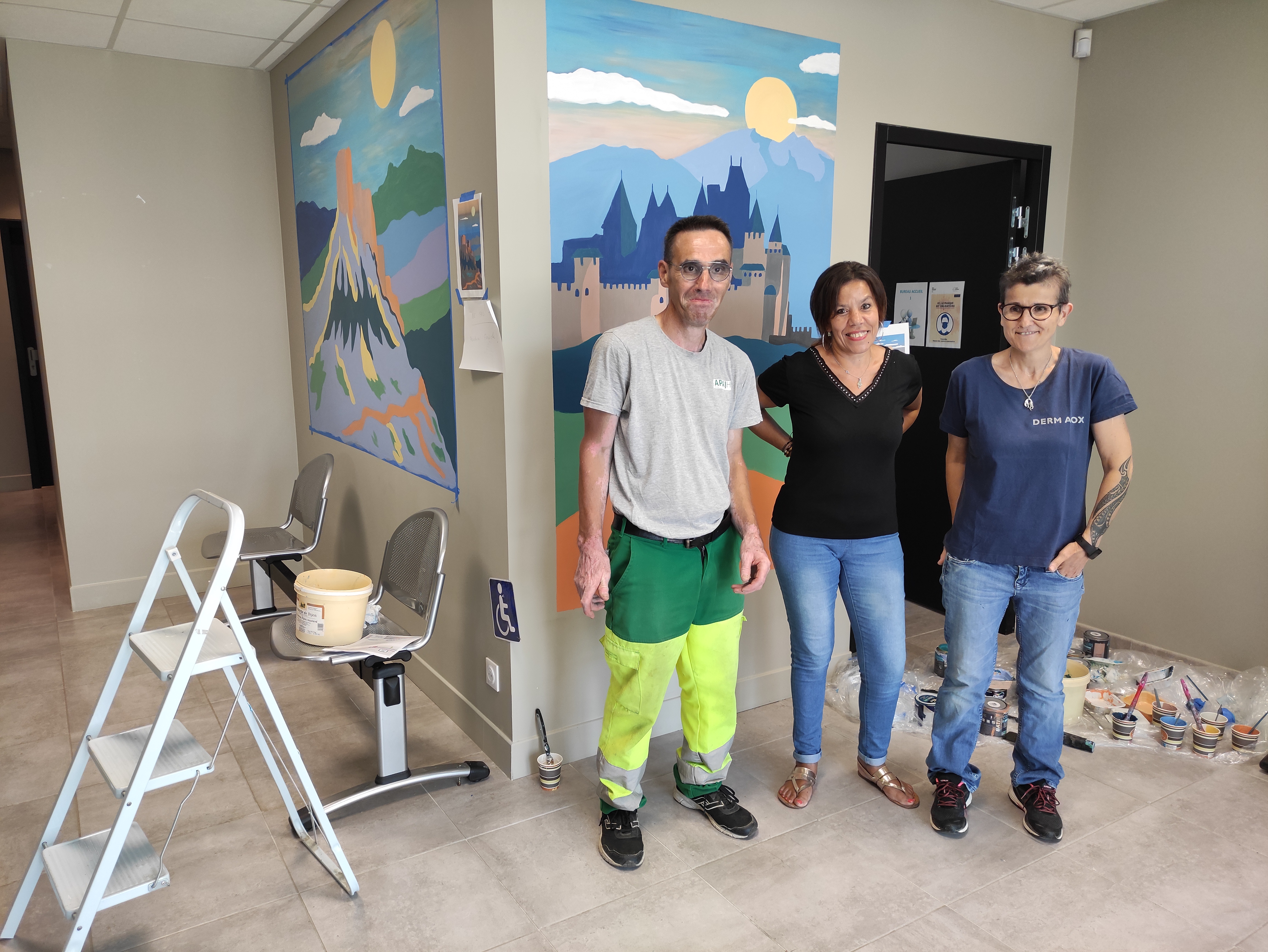 Malika, Anne-Marie et Jean-Pierre posent devant l'oeuvre du hall d'accueil